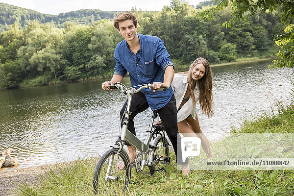 Young couple with bicycle at lakeside