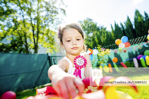 Little girl having birthday party in the garden