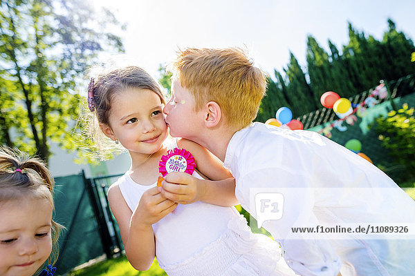 Little boy kissing little girl at birthday party
