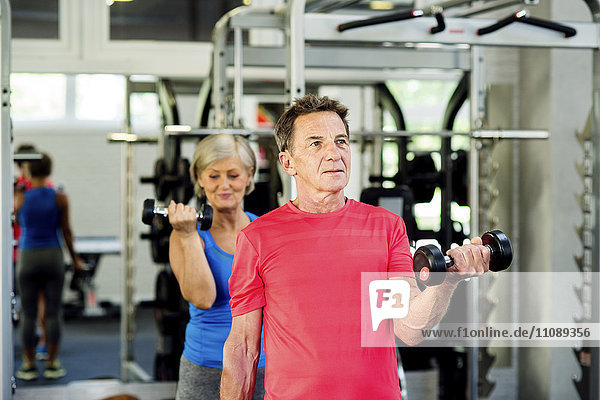 Senior Mann und reife Frau beim Training im Fitnessstudio