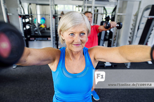 Mature woman and senior man working out in fitness gym