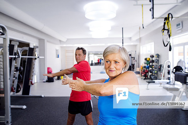 Reife Frau und älterer Mann beim Turnen im Fitnessstudio