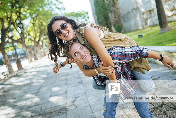 Young man giving his girlfriend a piggyback ride