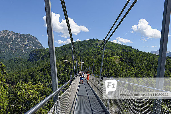 Austria  Tyrol  People standing on supensiion bridge near castle ruin Ehrenberg