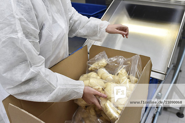 Arbeiter beim Verpacken von Croissants in einer Backfabrik