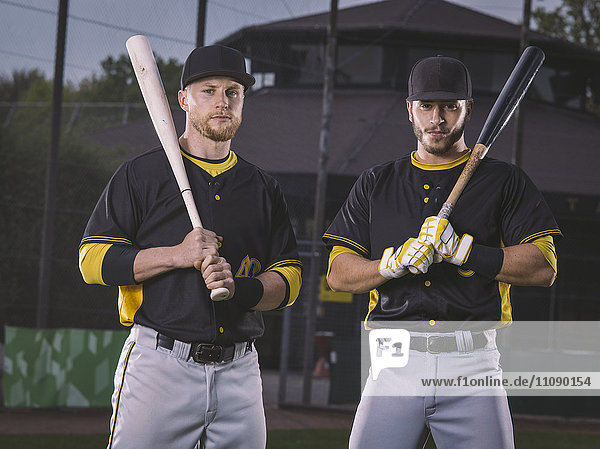 Porträt zweier selbstbewusster Baseballspieler mit Fledermäusen