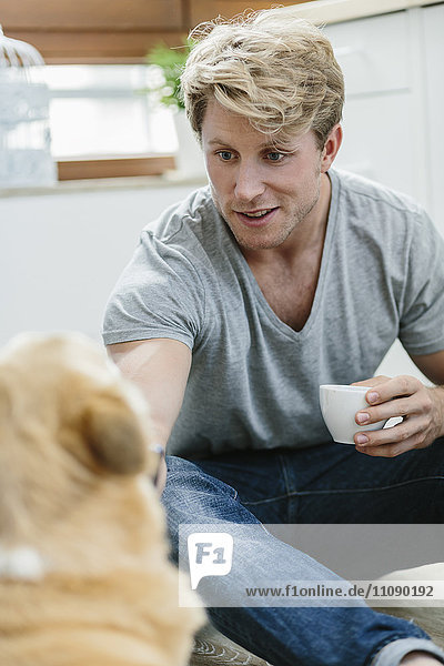 Blonder Mann füttert Hund