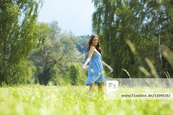 Young woman  blue dress  on meadow