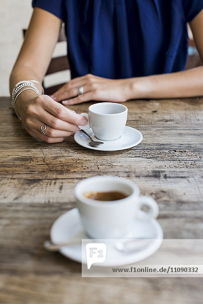 Frau trinkt Espresso in einem Straßencafé  Teilansicht