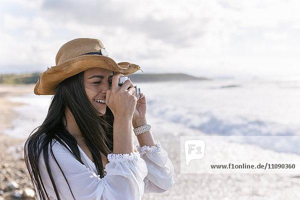 Asturien  Spanien  schöne junge Frau mit Kamera am Strand