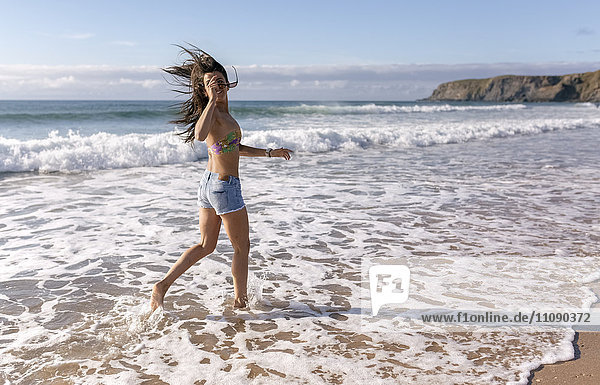 Spain  Asturias  beautiful young woman running on the beach
