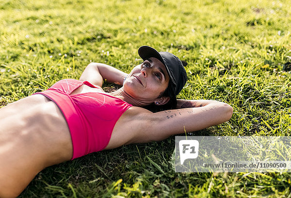 Female athlete resting on grass