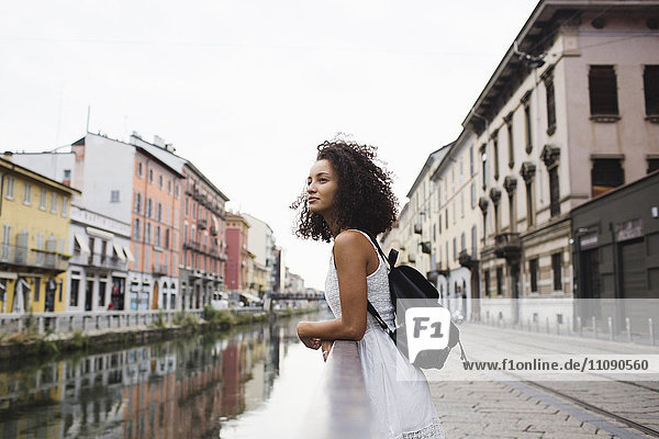 Italien  Mailand  junge Frau mit Rucksack  die sich auf das Geländer stützt und in die Ferne schaut.