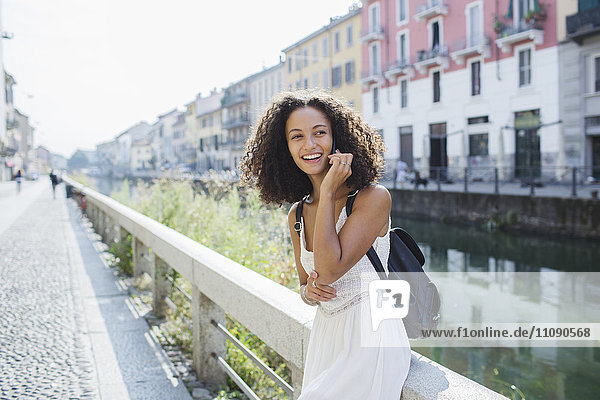 Italien  Mailand  Porträt einer lächelnden jungen Frau am Telefon