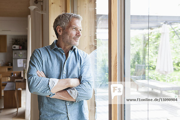 Mature man looking out of window