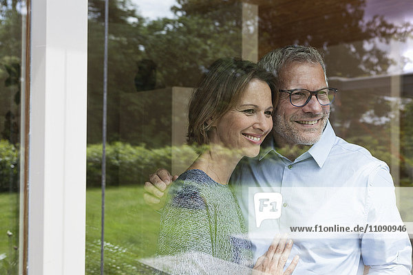 Smiling mature couple looking out of window