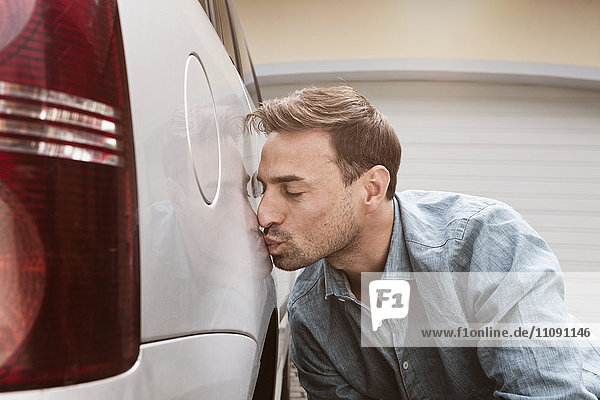 Mann küsst sein sauberes Auto