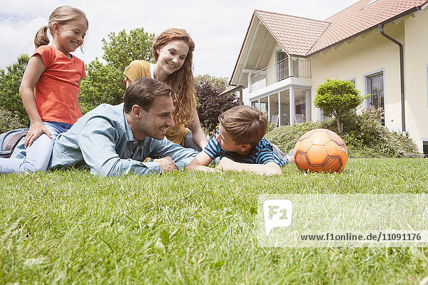 Smiling family in garden with football