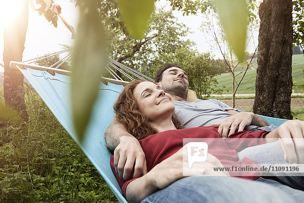 Couple relaxing in hammock