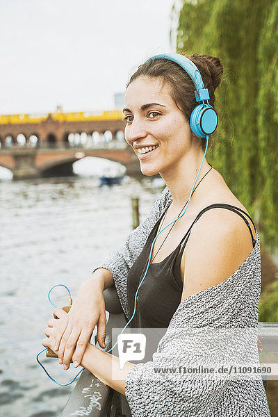 Deutschland  Berlin  entspannte Frau beim Musikhören mit Kopfhörer