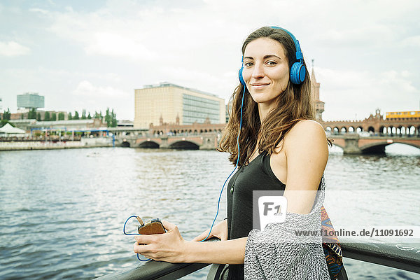 Deutschland  Berlin  Portrait einer entspannten Frau beim Musikhören mit Kopfhörer