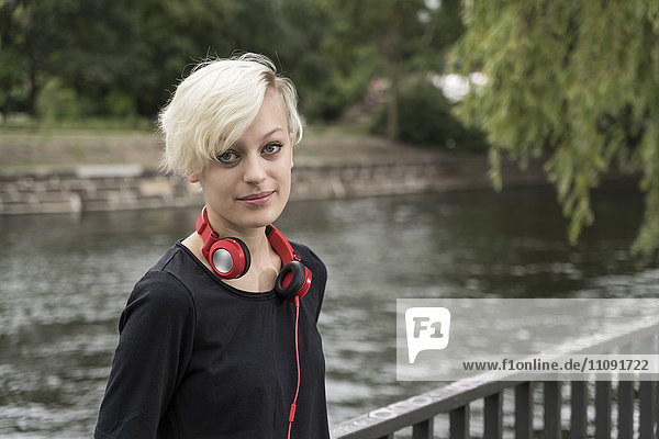 Portrait einer blonden jungen Frau mit Kopfhörer