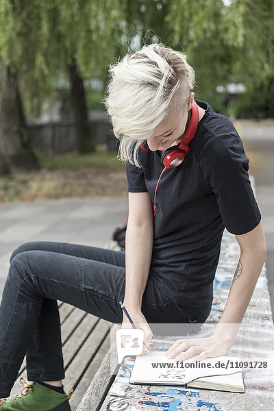 Junge Frau mit Kopfhörerzeichnung auf Parkbank