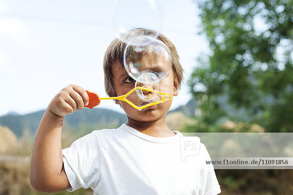 Little boy blowing soap bubbles