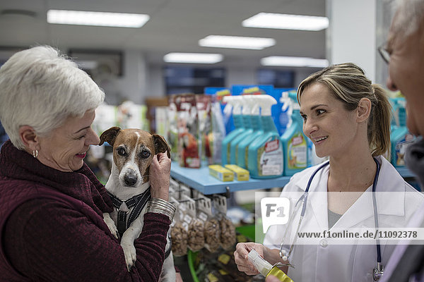 Seniorin mit Hund im Geschäft beim Tierarzt