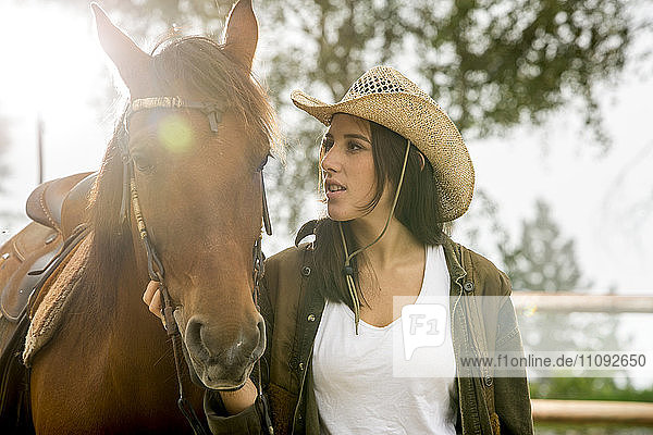Young woman with horse at riding stable