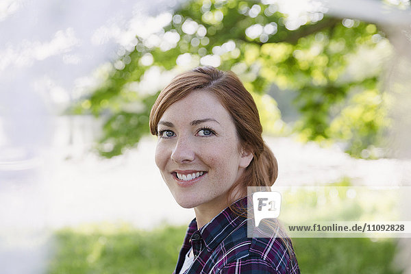 Portrait smiling woman with red hair outdoors