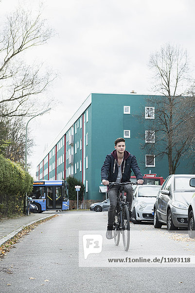 Junger Mann fährt Fahrrad auf der Straße
