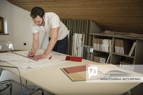 Architekt bei der Anfertigung eines Bauplans im Büro  Bayern  Deutschland