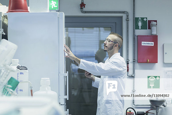 Young male scientist reading notes in a pharmacy laboratory