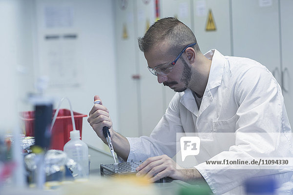 Wissenschaftler pipettiert Probe in Reagenzglas
