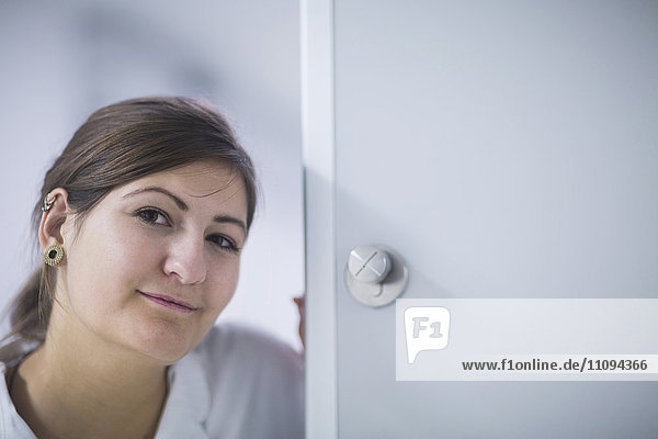 Porträt einer jungen Ärztin an der Tür im Krankenhaus
