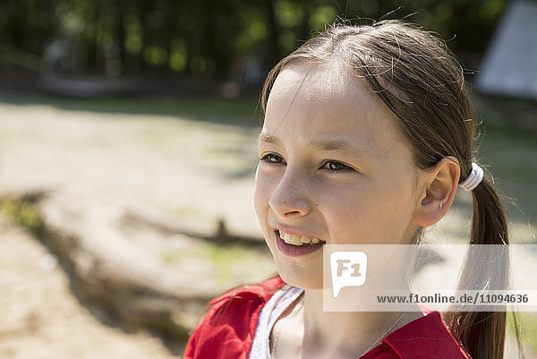 Nahaufnahme eines lächelnden Mädchens auf einem Spielplatz  Bayern  Deutschland