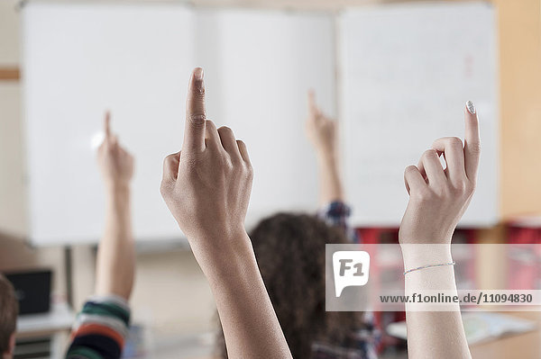 Universitätsstudenten heben ihre Hände im Klassenzimmer,  Bayern,  Deutschland