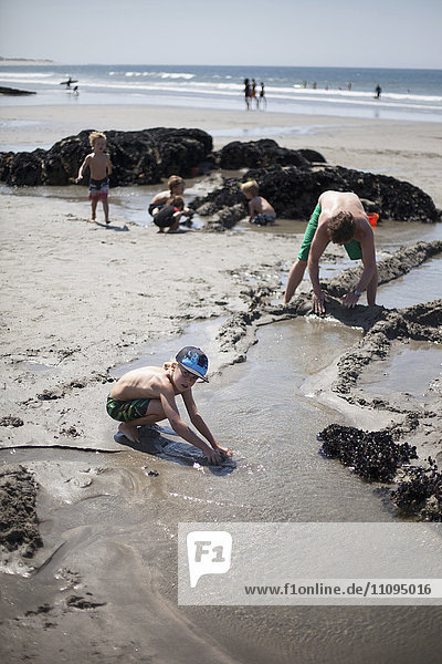 Vater baut mit seinen Kindern eine Sandburg am Strand  Viana do Castelo  Region Norte  Portugal