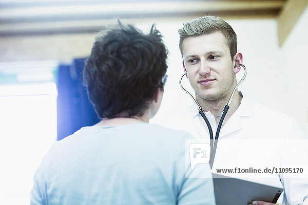 Mature patient talking to young doctor in a hospital  Freiburg Im Breisgau  Baden-Württemberg  Germany