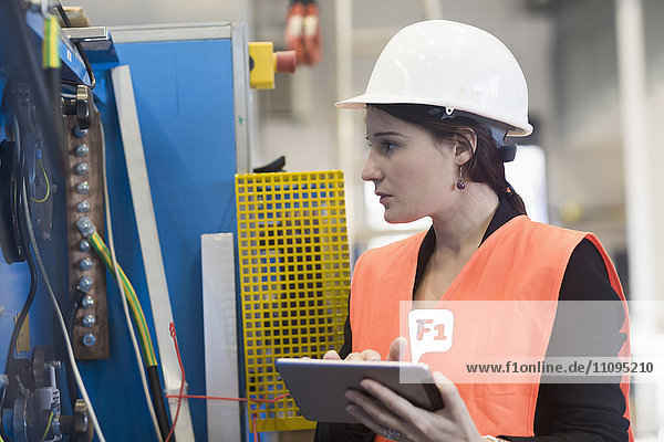 Ingenieurin bei der Arbeit mit einem digitalen Tablet in einer Industrieanlage  Freiburg im Breisgau  Baden-Württemberg  Deutschland