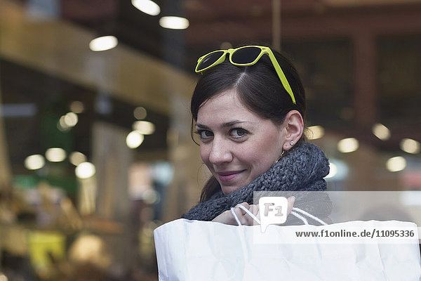 Portrait of a young woman with shopping bag in the shop  Freiburg im Breisgau  Baden-Württemberg  Germany