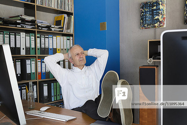 Älterer Geschäftsmann sitzt im Büro und denkt nach  Freiburg im Breisgau  Baden-Württemberg  Deutschland