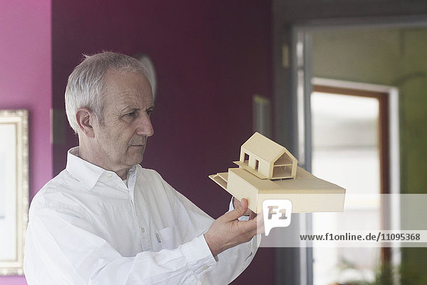 Leitender Architekt bei der Arbeit an einem Modellhaus und im Büro  Freiburg im Breisgau  Baden-Württemberg  Deutschland