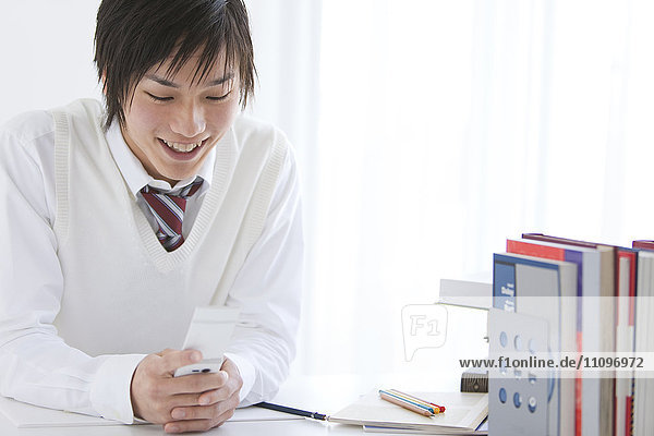 High School Student at Desk with Mobile Phone