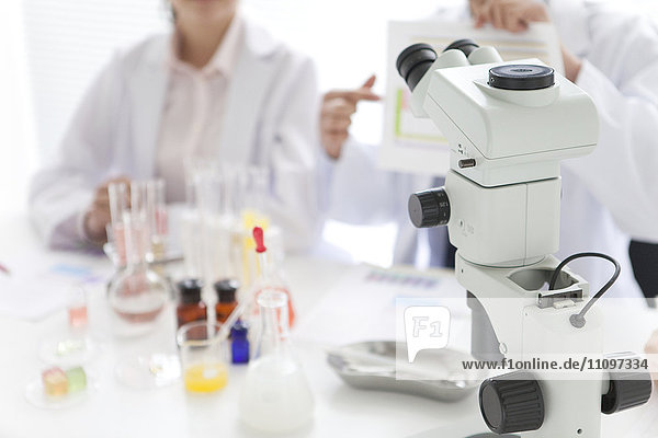 Mikroskop und Wissenschaftler im Hintergrund