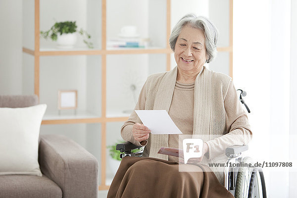 Senior Woman on Wheelchair Reading Letter
