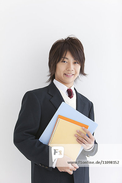 School Boy in Uniform Holding Notebooks
