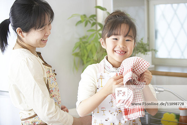 Mother and daughter washing dishes