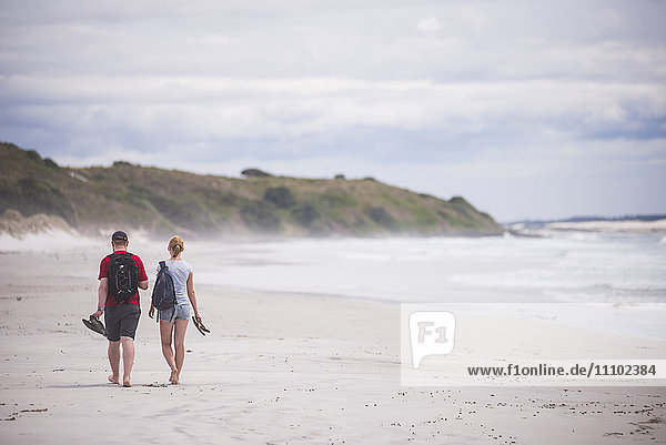 Tourists walking on Rarawa Beach  a popular and beautiful white sand beach in Northland Region  North Island  New Zealand  Pacific